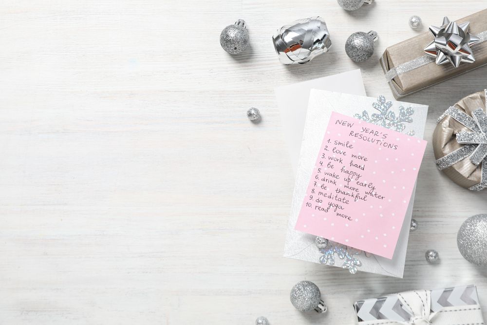 Paper with list, gift boxes and decorations on light background, space for text