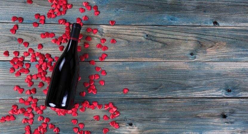 Valentine’s day celebration with wine and hearts on faded blue wood