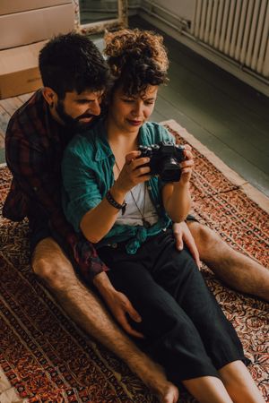 Young couple using photo camera at home