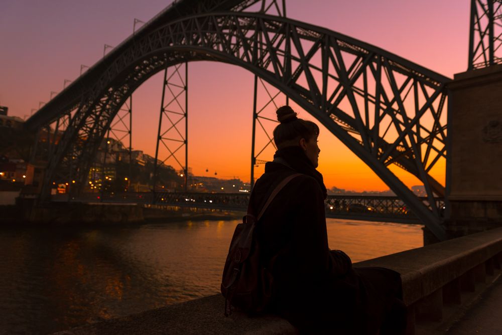 Woman looking at river and city in evening