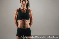 Muscular woman with arms behind back 5ngOal