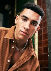 Portrait of man in corduroy shirt and silver chain
