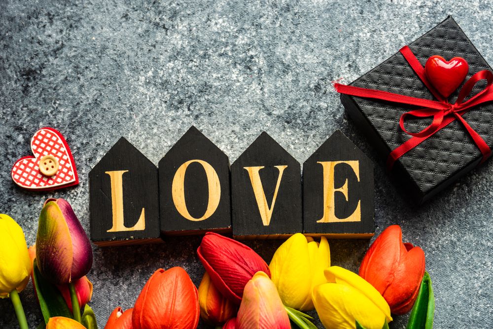 Fresh tulips on grey counter with giftbox & the word "love"