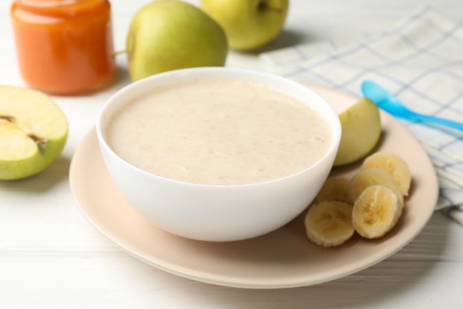 Composition with baby food on plain wooden background