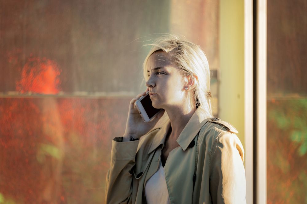Traveling woman speaking on the phone near an airport