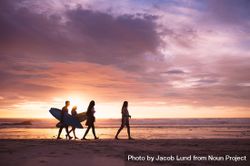 Silhouette of a group of friends walking on beach at dusk 4d1Mab