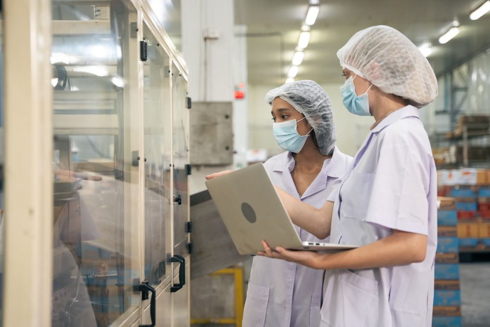 Industrial workers inspecting quality control of canned fish factory
