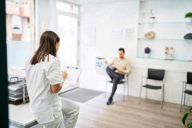 physiotherapist and patient at the clinic's reception desk