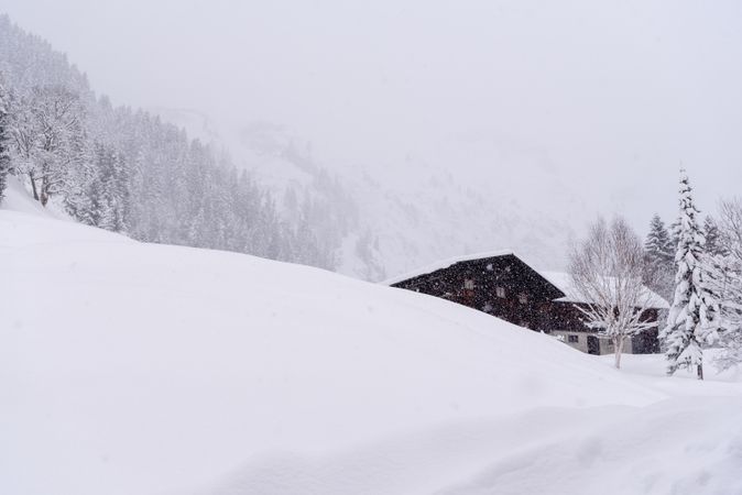 Mountain cabin on a blizzard surrounded by deep snow in the Bavarian Alps, Germany