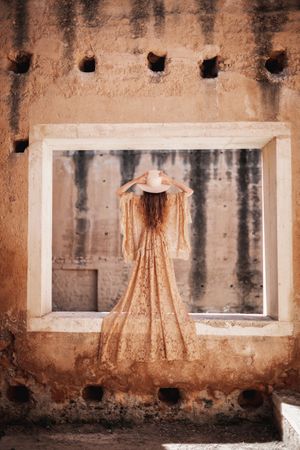 Elegant female in long dress on window