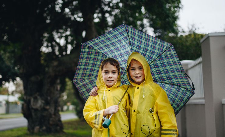 Portrait of beautiful two girls standing under an umbrella
