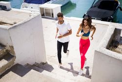 Male and female exercising on stairs near waterfront