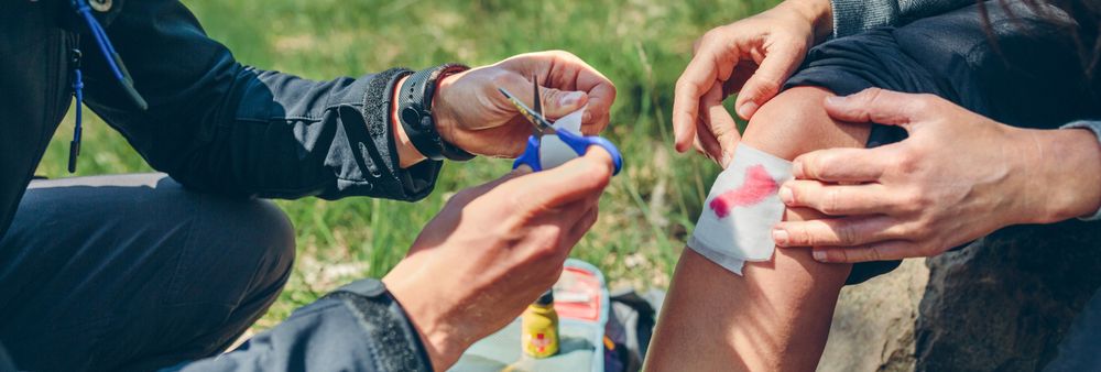 Man healing knee to woman who has been injured trekking