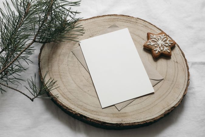 Blank greeting card, invitation mockup on cut wooden round board with star gingerbread cookie