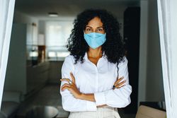 Woman in facemask with her arms crossed