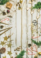 Decorations of stars, candy canes, scissors, candles on light background, vertical composition