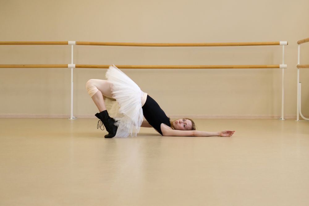 Ballerina in shoes and tutu, lying on floor
