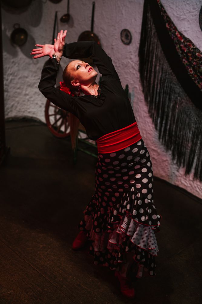 Woman dancer in flamenco costume standing in dance posture