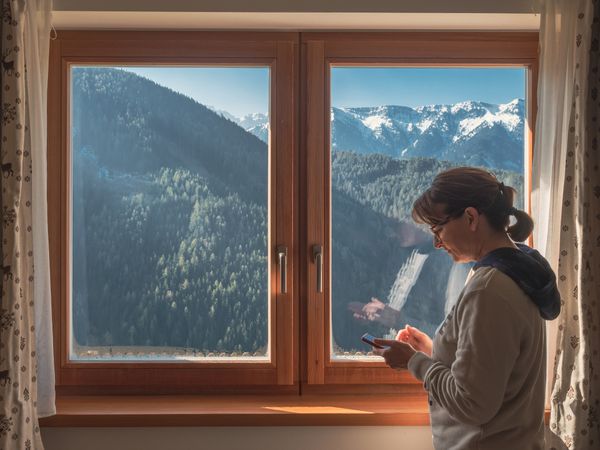 Woman browsing smartphone near window