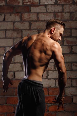 Bodybuilder competitor practicing back poses ahead of competition