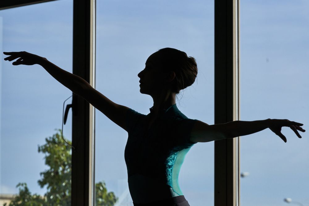 Photo portrait of a white woman dancer in sports clothes and ballet shoes in a dance academy