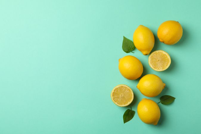 Fresh lemons on mint background, top view. Ripe fruit
