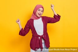 Woman in red headscarf with both arms up in excitement 4AqNQ4
