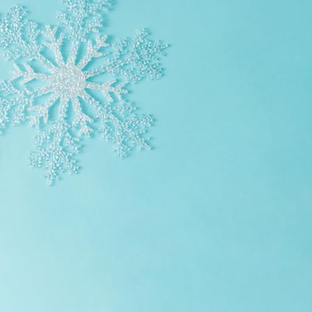 Single large snowflake on bright blue background