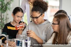 Multi-ethnic female students in science class doing chemical experiment in laboratory 5aRn84