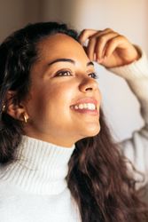 young woman sitting on sofa near window with warm light