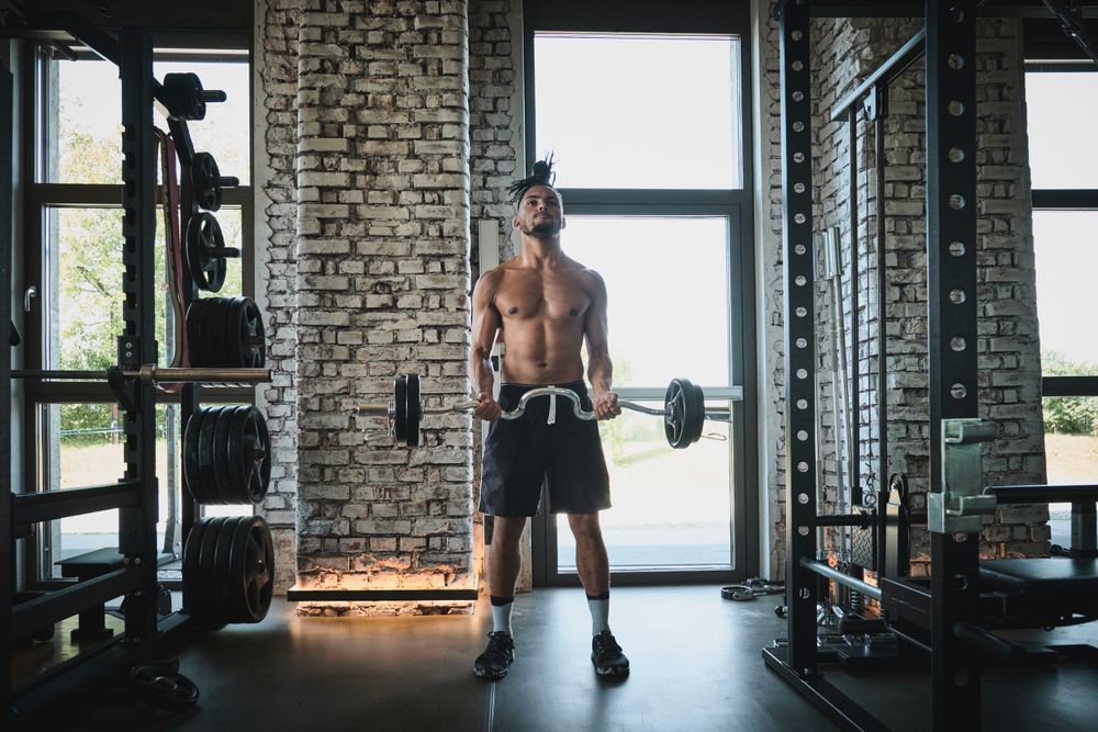Black man exercising with barbell in gym