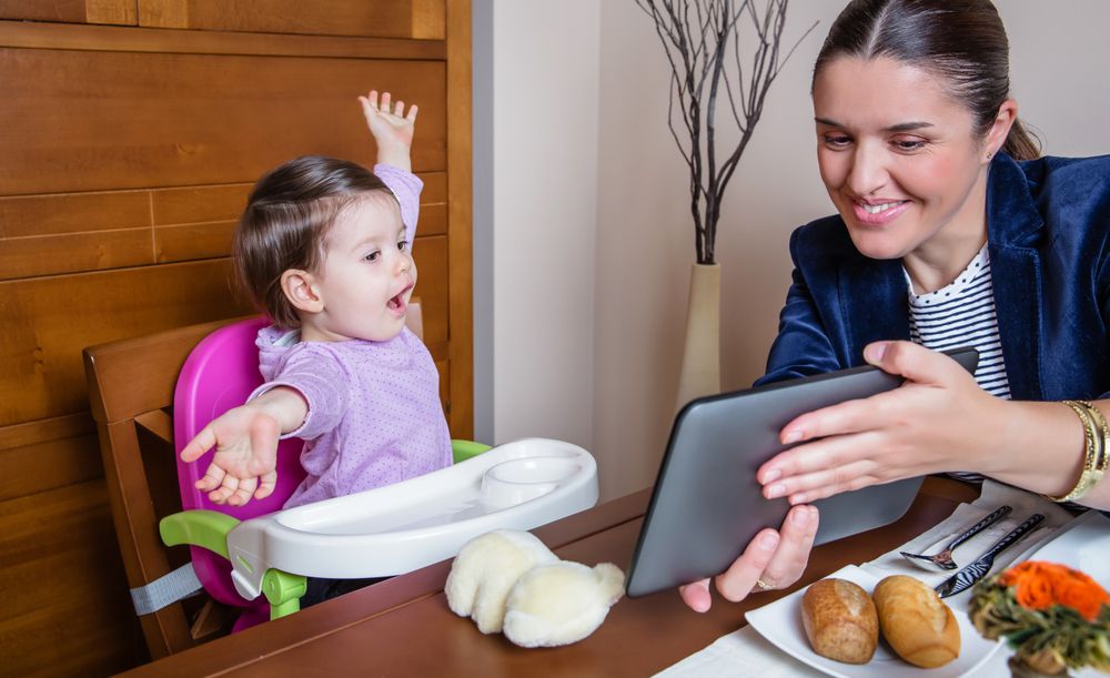 Businesswoman mother and baby girl looking tablet
