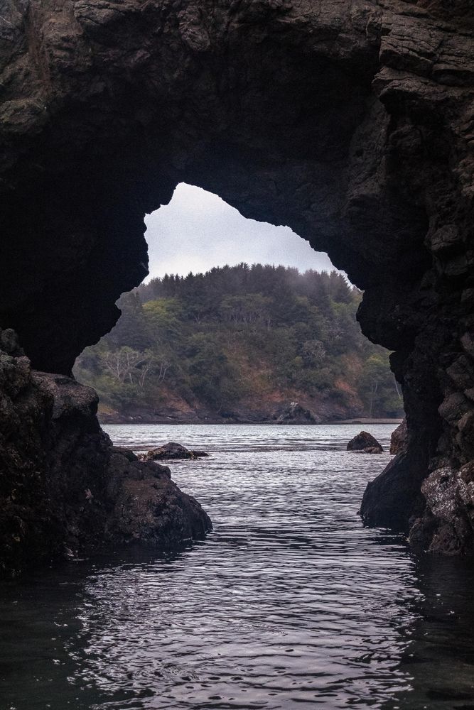 Rocky cove creating an opening in the water, vertical