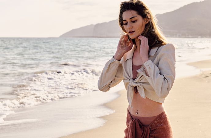A fashion model at the beach before sunset