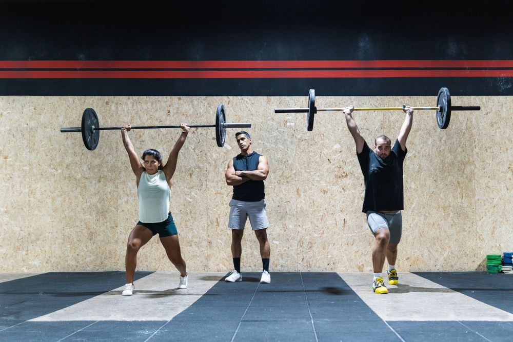Hispanic sportspeople training with barbells