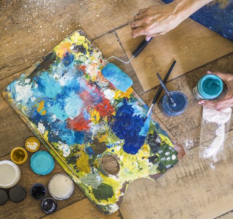 High angle view of brushes, pallete, oils, acrylics and other elements of a painter artist. Art workshop. Background.