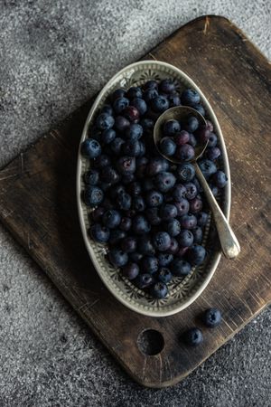 Top view of blueberries in ceramic dish with spoon
