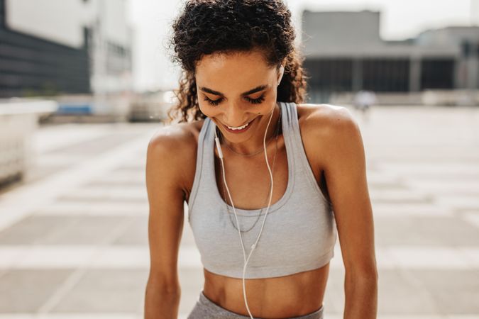 Fit woman taking a break from workout looking down and smiling