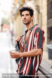 Male in striped shirt standing in the streets of Granada, Spain with coffee 4ZeNN9