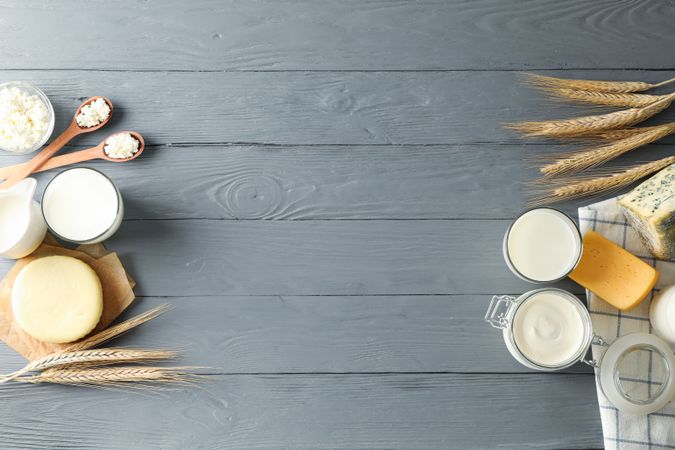 Flat lay. Different dairy products on grey wooden background, copy space