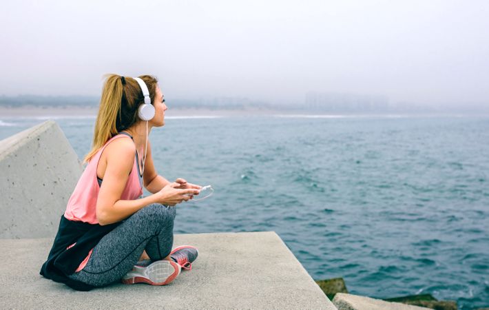 Sitting sportswoman watching the sea
