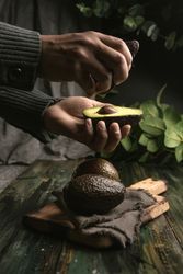 Person hands holding avocados