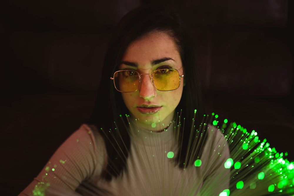 Young woman with fairy lights in darkness