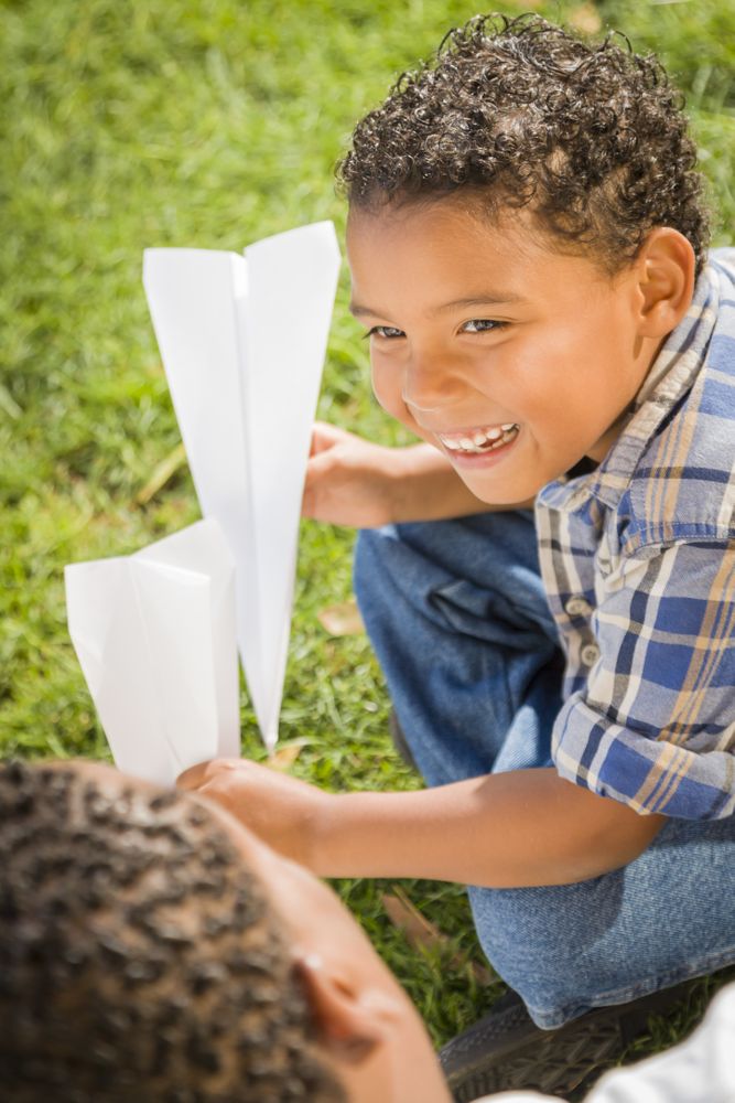 Father and Son Having Fun with Paper Airplanes