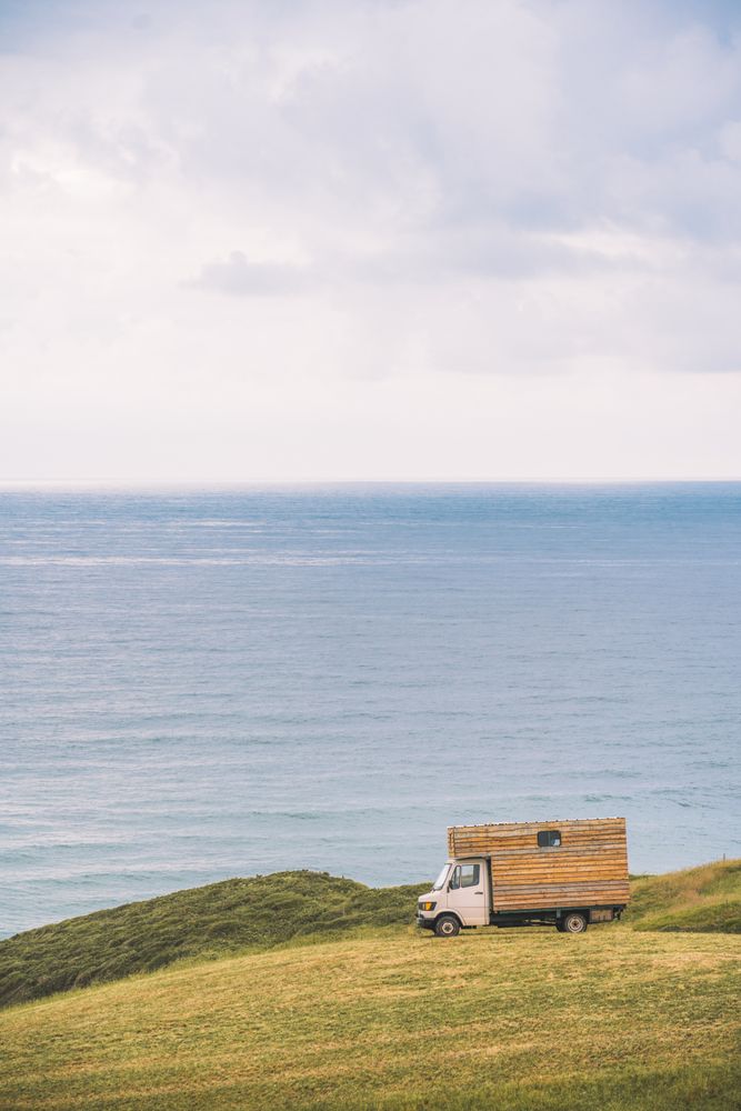 Landscape of empty meadow with passing truck near seaside