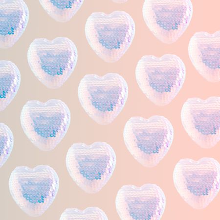 Pattern of iridescent sequins hearts on pink background