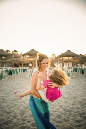 Woman with naughty boy on hands on beach