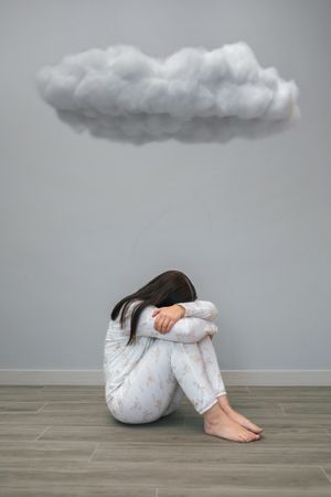 Woman crying under a dark cloud