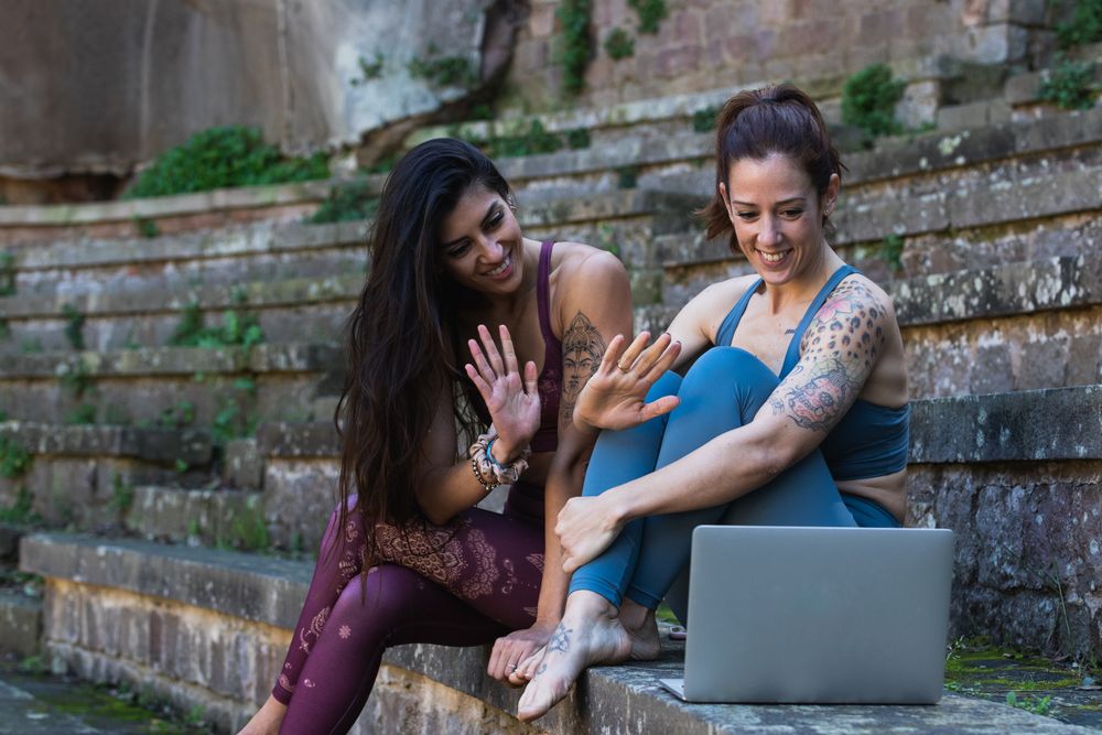 Content diverse women having yoga lesson via laptop