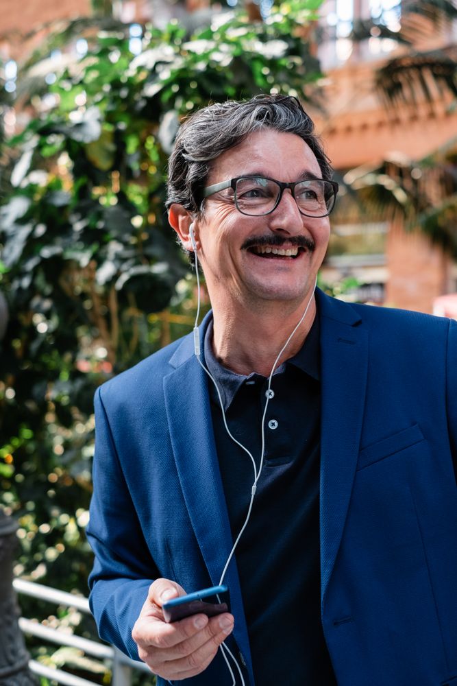 Older businessman using smartphone with headphones and smiling